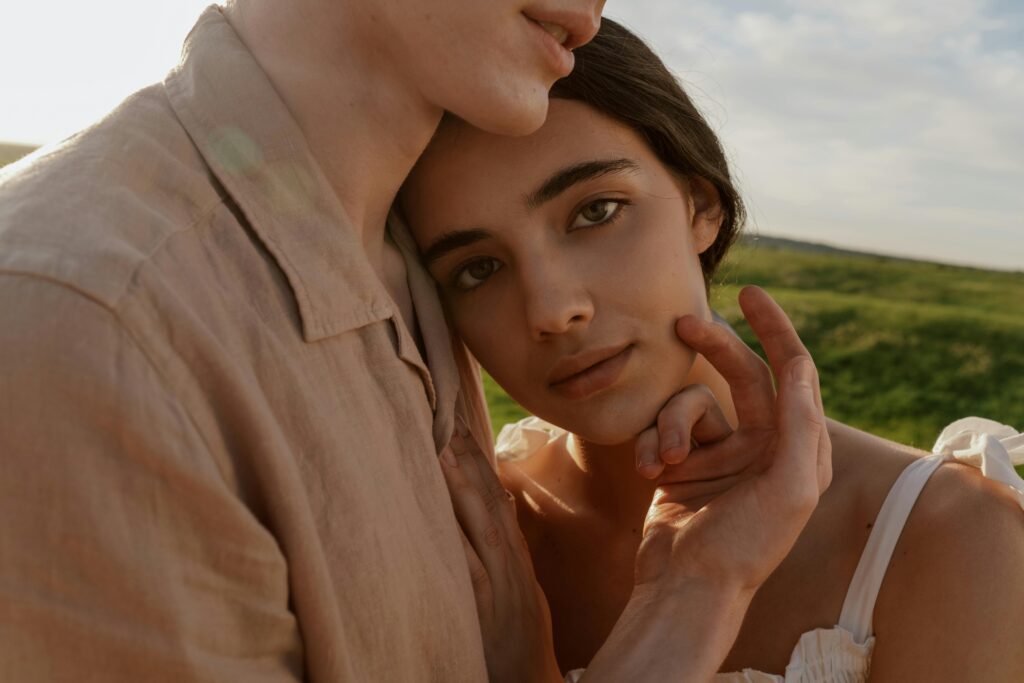 A warm intimate moment captured between a couple embracing in a natural setting.